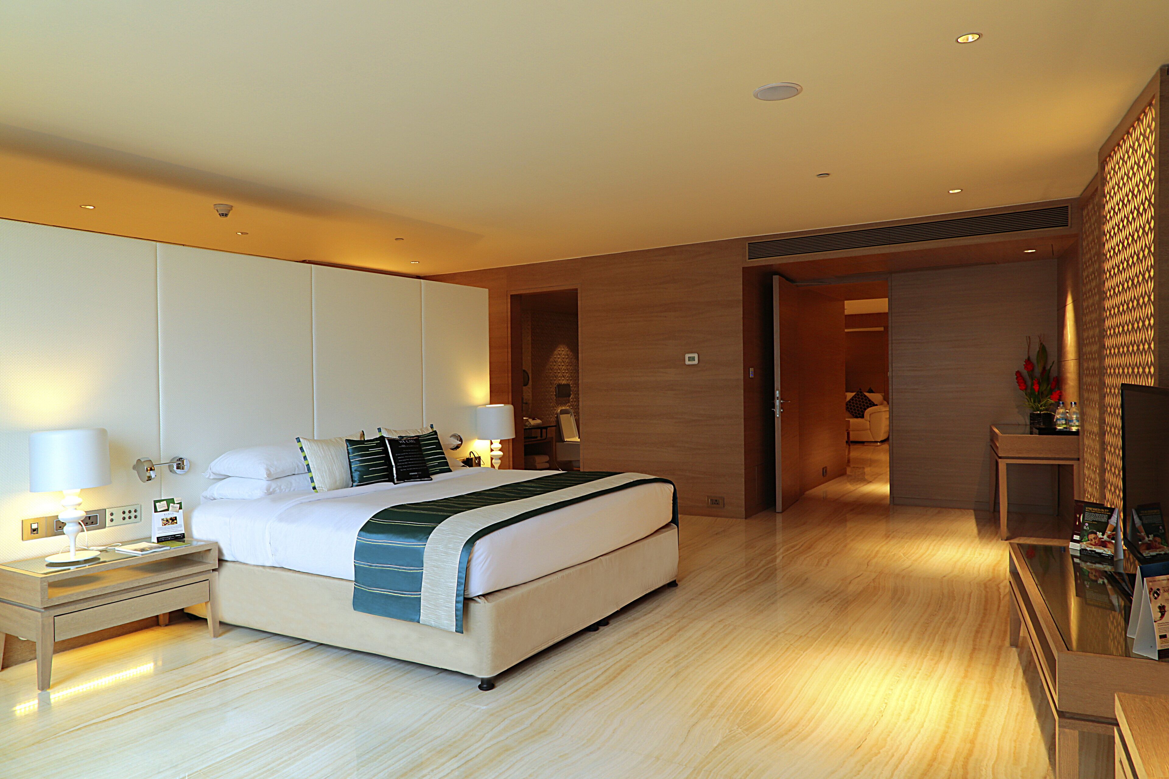 Una camera d'hotel moderna con un letto grande, comodini, una scrivania e un televisore.