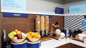 A breakfast bar with fruit bowls, cereal dispensers, and a coffee machine. - Holiday Inn Express & Suites Grande Prairie by IHG (Grande Prairie)