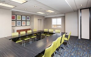 A conference room with a long table and yellow chairs, framed artwork on the wall, and a window providing natural light. - Holiday Inn Express & Suites Grande Prairie by IHG (Grande Prairie)