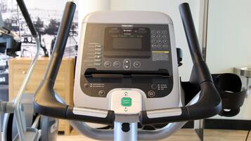 Una bicicleta estática con pantalla digital, panel de control y un botón de 'Quick Start'.