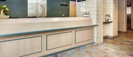 A hotel reception desk with a 'Motel 6' sign, a reception area, and a tiled floor.