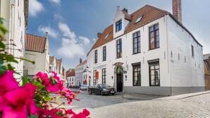 Een wit gebouw met een bord waarop 'Hotel De Goezeput' staat, gelegen aan een kinderafgesloten straat.