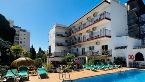 Un hôtel doté d’une piscine, d’un espace extérieur aménagé et de plusieurs balcons.