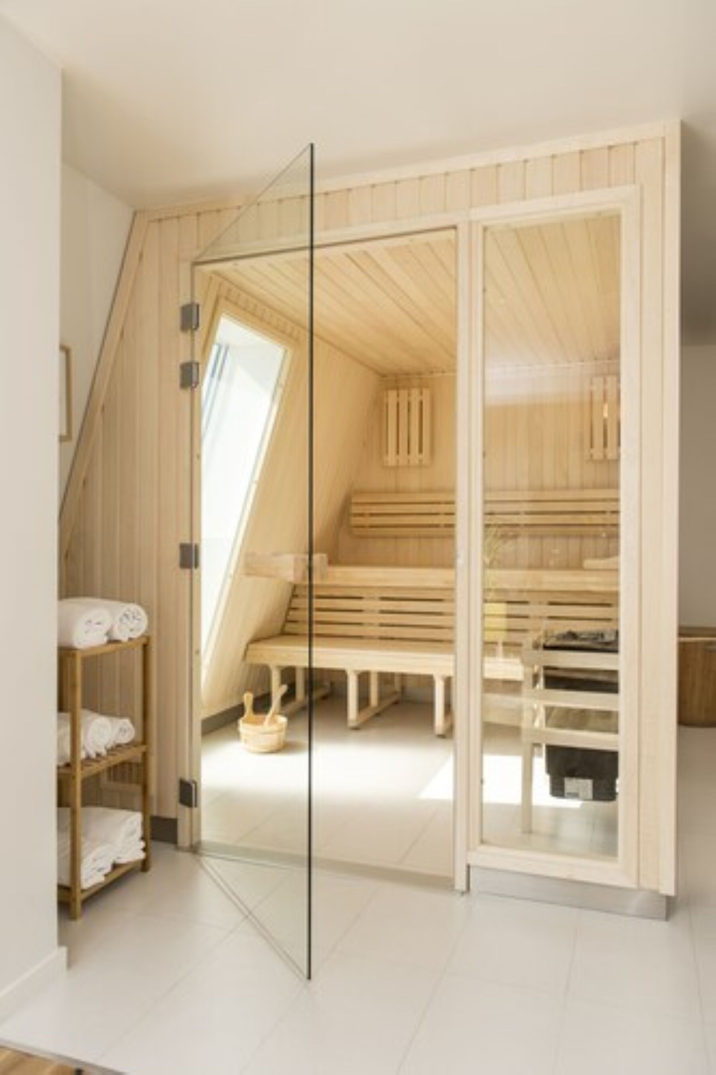 A sauna room with wooden benches and a glass door.