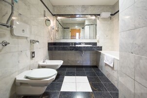Un baño moderno con dos inodoros, un lavamanos y un espejo.
