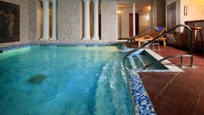 An indoor swimming pool with clear blue water, surrounded by columns and patterned walls. - OREA Spa Hotel Palace Zvon Mariánské Lázně (Marianske Lazne)
