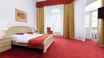 Une chambre d’hôtel avec un grand lit, une chaise, une table et un tableau au mur.