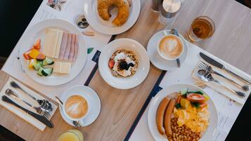 Un desayuno con diversos platos, como un bagel, huevos y café.