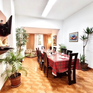 A dining area with a red checkered tablecloth, wooden chairs, and potted plants. - Casa Bella Boutique Hotel San Isidro (Lima)