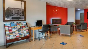 Hotellin aula, jossa on vastaanottotiski, tietokone ja oleskelualue.