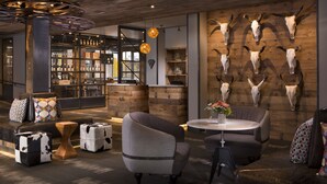 Ein modernes Interieur mit Barbereich, Holzboden und einer Wand, die mit Tierkopfschädeln verziert ist.