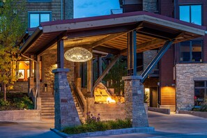 A hotel entrance with a covered outdoor area, stone pillars, and a staircase leading to the entrance. - Hotel Terra Jackson Hole - A Noble House Resort (Teton Village)