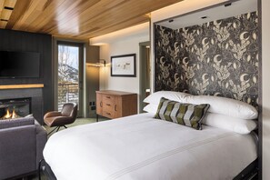 Una habitación de hotel moderna con chimenea, una cama grande, un armario de madera y una pared con un diseño celestial.