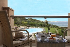 Enjoy a peaceful morning on this balcony overlooking the pool and lush surroundings.