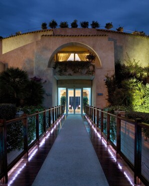 Stroll through lush greenery to the entrance, where an arched doorway invites you in.
