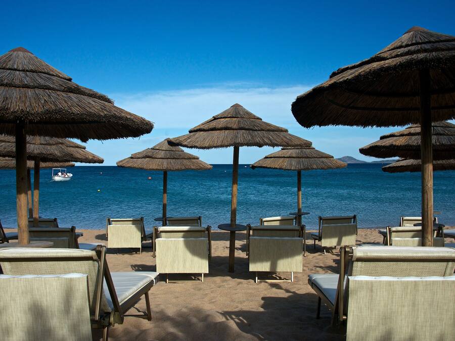 En privat strand, hvidt sand, liggestole, parasoller