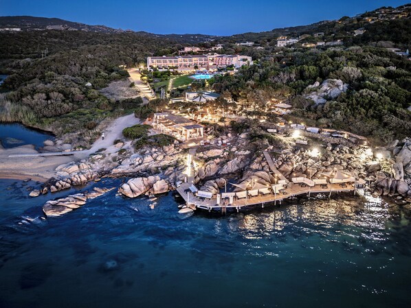 Un resort costero con un edificio grande, varias piscinas y un litoral rocoso.