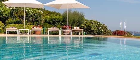Piscine extérieure, parasols de plage, chaises longues