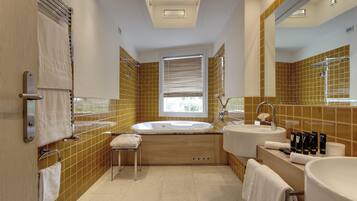 A modern bathroom with a bathtub, two sinks, and a window.