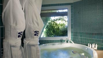 Relax in a serene space with a bathtub and green tile accents.