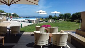 Relax in style with a tranquil poolside retreat, featuring a garden and comfortable seating area.