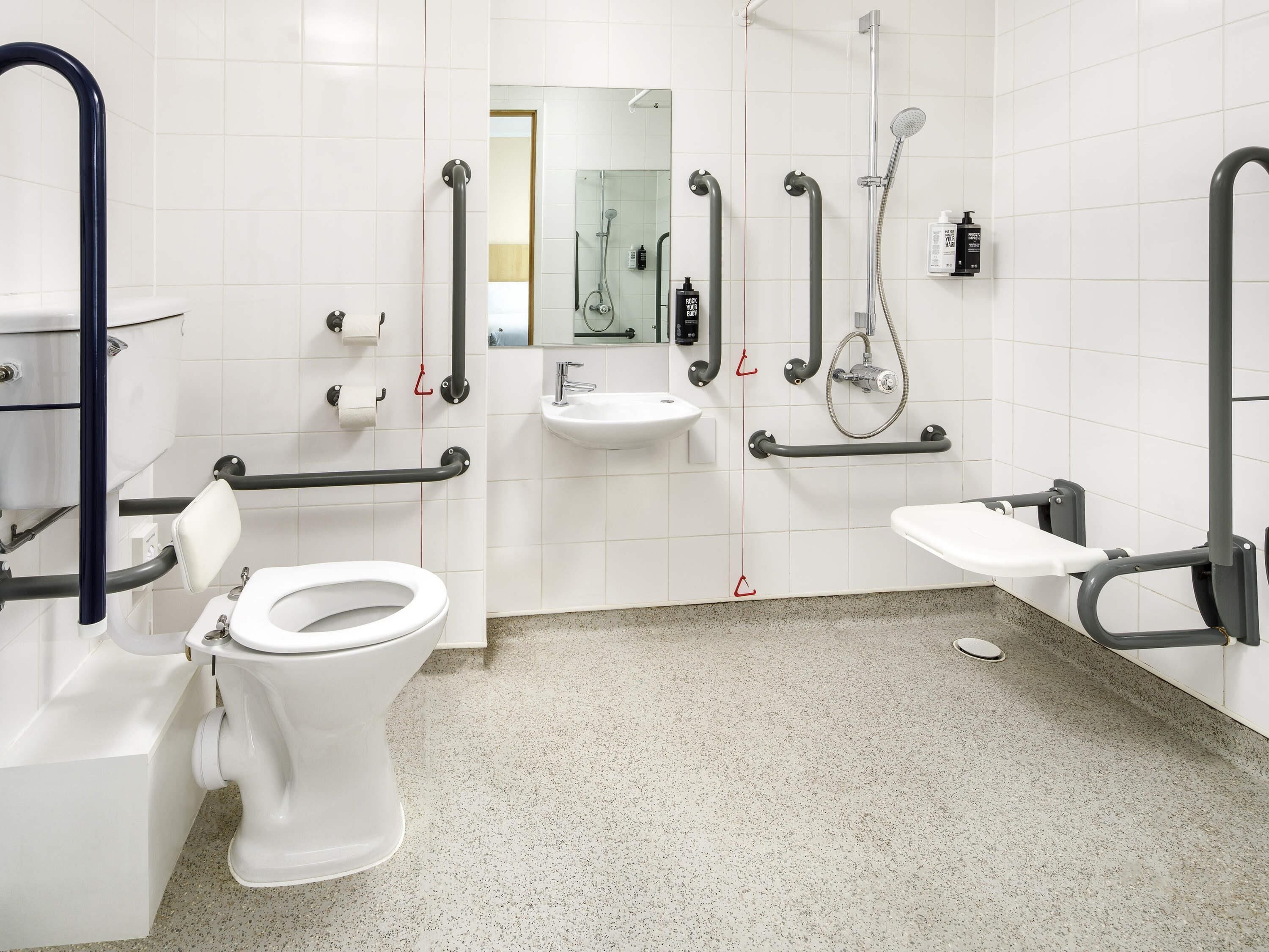 A modern bathroom with a toilet, sink, and shower.