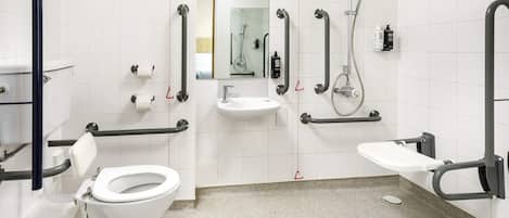 A modern bathroom with a toilet, sink, and shower.