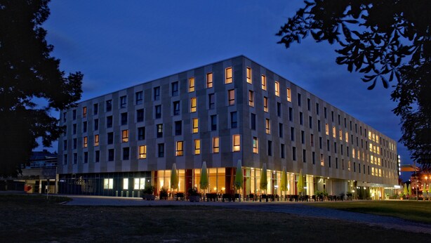 Un hotel moderno con diseño rectangular, varios pisos y techo plano.