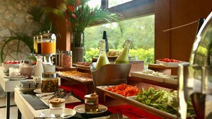 A buffet setup with various food items and beverages, including a salad bar, fruit, and a beverage station. - Los Mandarinos Hotel Boutique & Spa (El Valle de Anton)