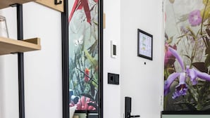 A room with a large mirror, wooden shelves, a door, and a wall-mounted picture. - Dutch Design Hotel Vondelpark (Amsterdam)