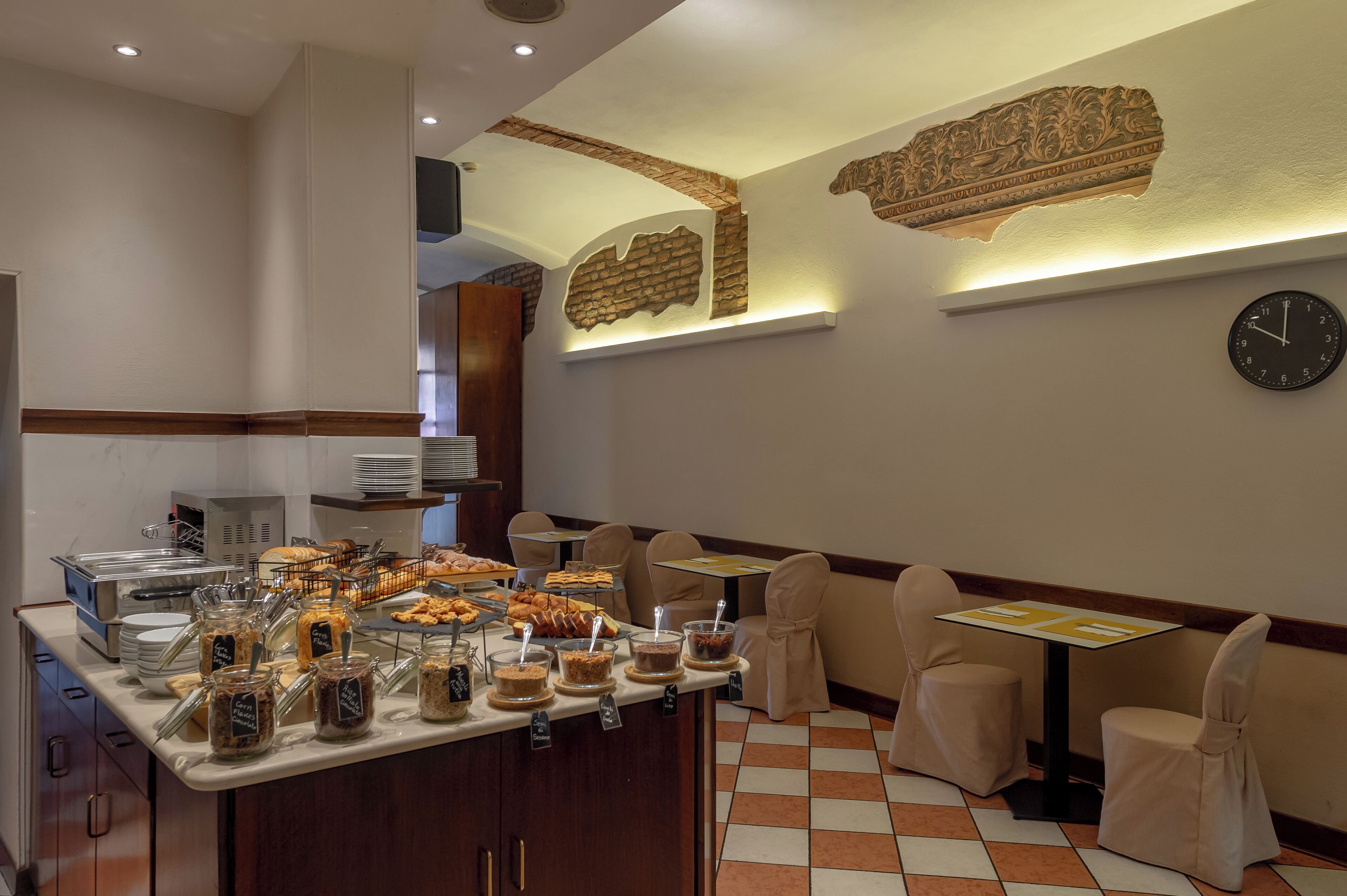 Un área de bufé con diferentes opciones de comida y un reloj en la pared.