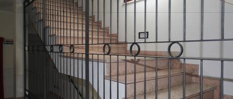 Eine Treppe mit Metallgeländer, die zu einer oberen Etage führt.