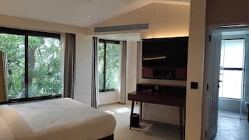 A modern hotel room with a large bed, a desk, and a flat-screen TV.