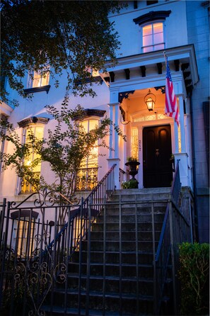 A building with a dark entrance door, a number '217' above it, and an American flag to the right. - Justine Inn Savannah (Savannah)