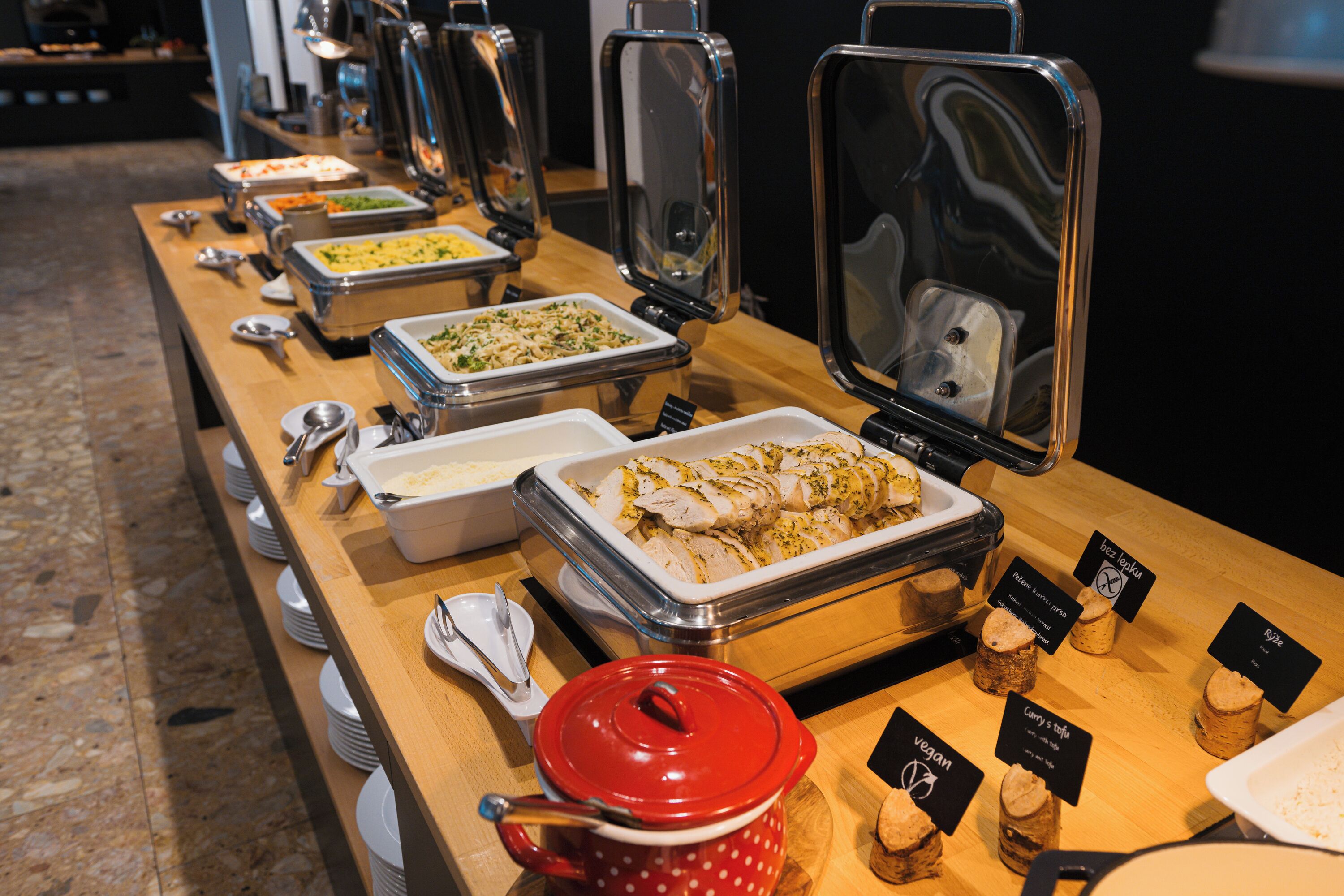 A buffet setup with various food items and serving utensils.