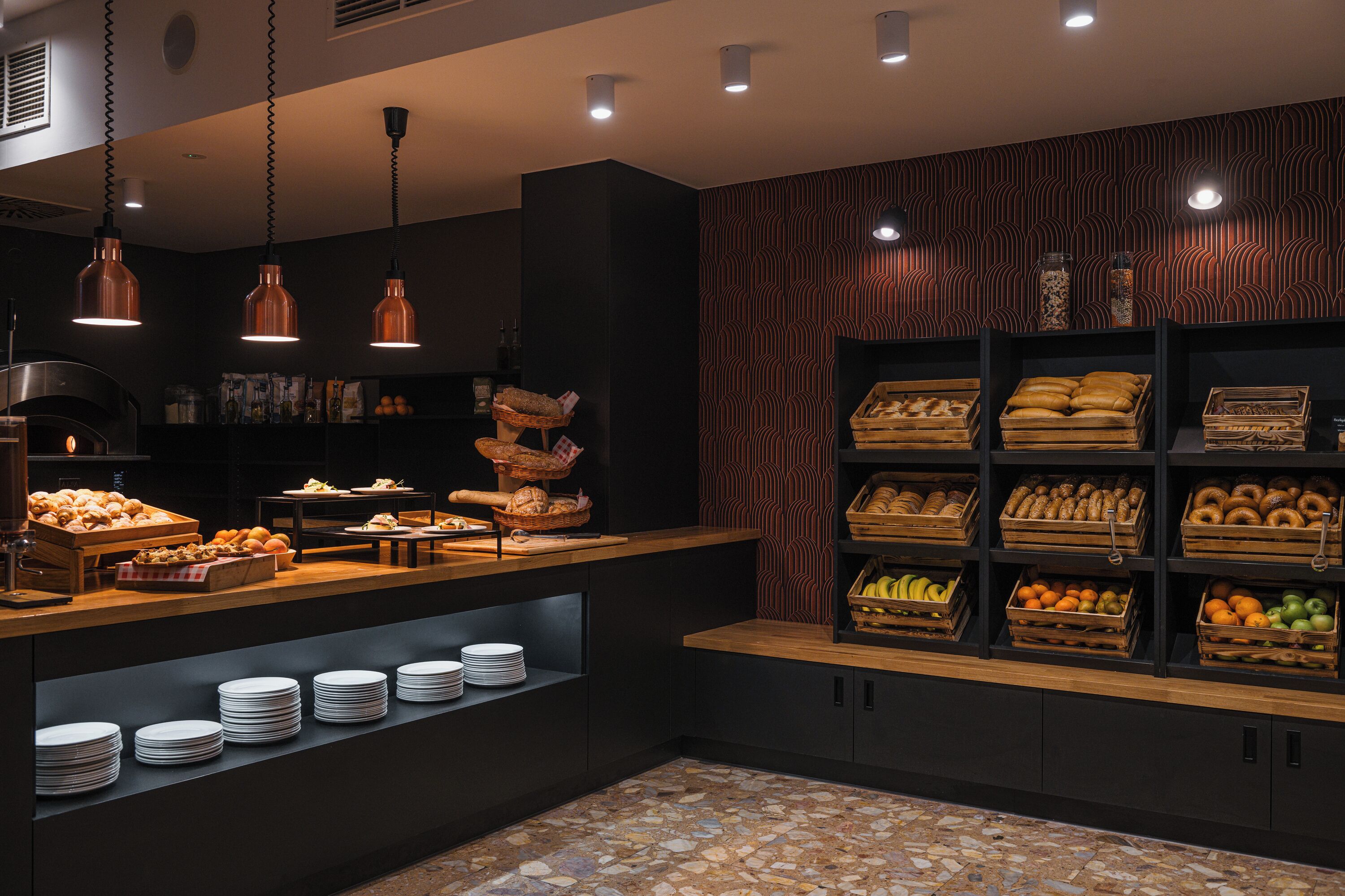Un mostrador de panadería con diversos productos horneados y una exhibición de frutas y verduras.