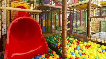 Children can play safely in this enclosed play area featuring a slide and ball pit.