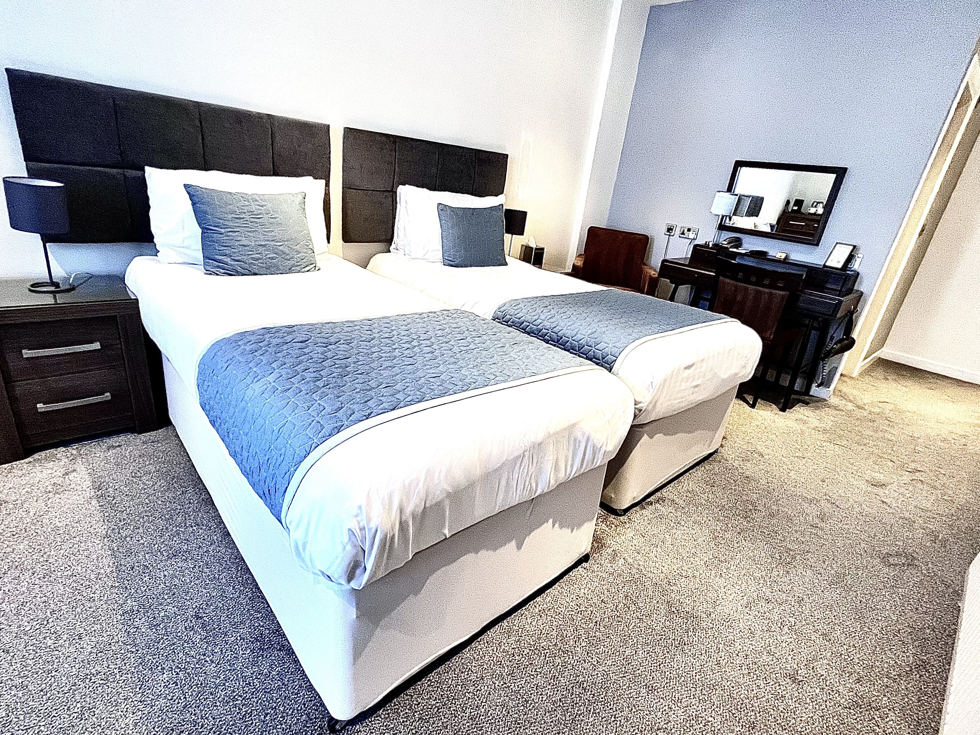 Een moderne hotelkamer met een groot bed, een bureau en een stoel.