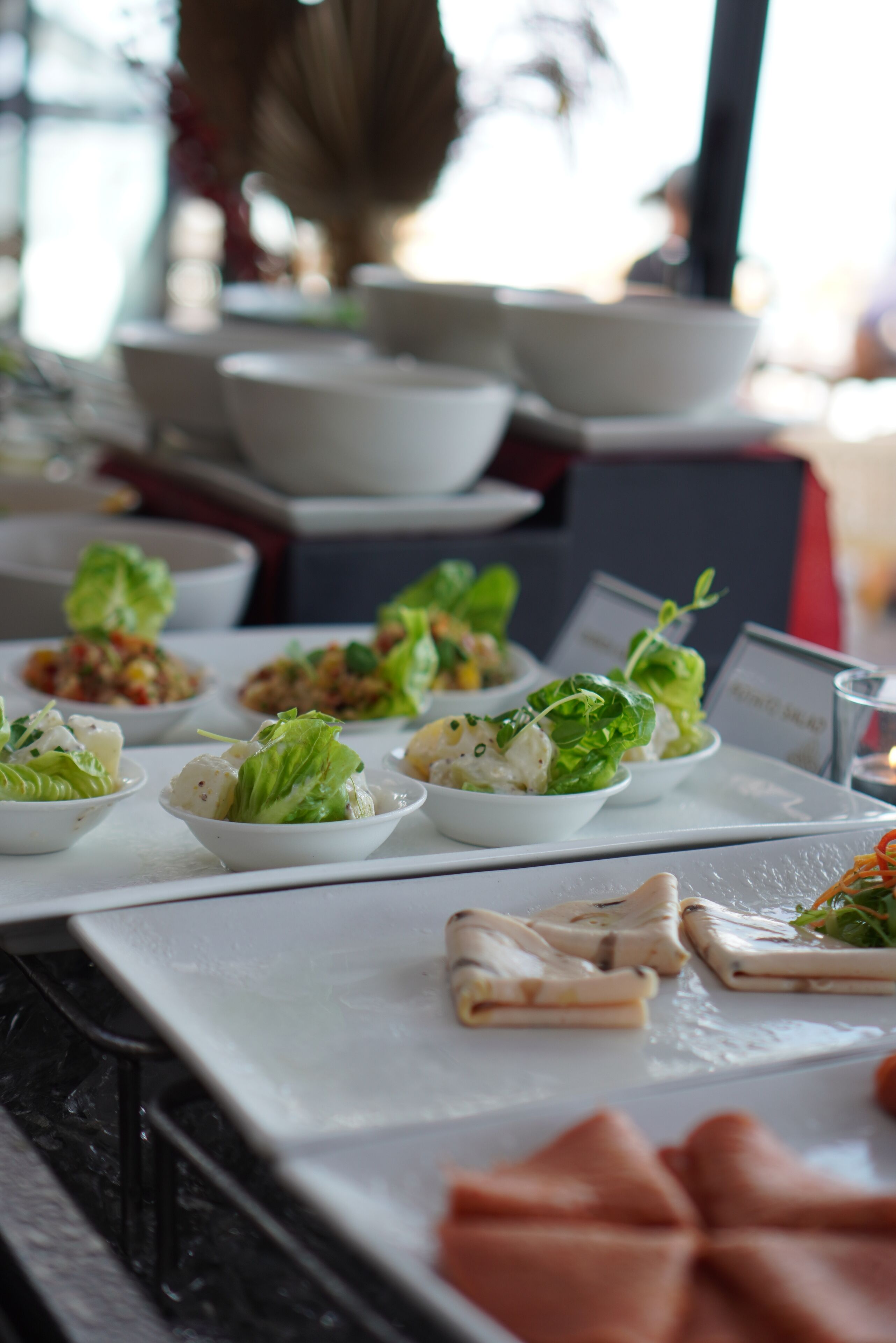A table with various dishes, including salads and appetizers, arranged on a white tablecloth.
