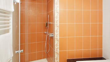 A bathroom with a shower, a bathtub, and a toilet.
