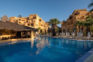 Una piscina cubierta, sombrillas, tumbonas