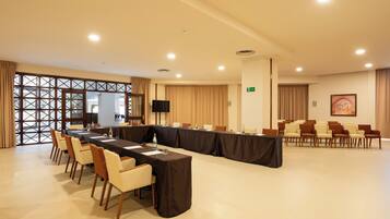 A conference room with a long table, chairs, and a television screen.
