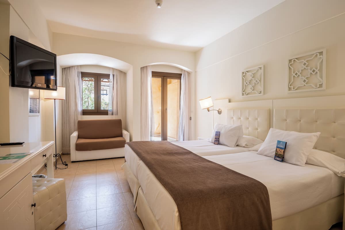 Ein Hotelzimmer mit einem großen Bett, einer Couch, einem Fernseher und einem Schreibtisch.