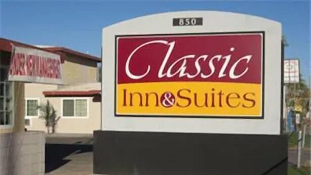 Señal de Classic Inn & Suites con vista despejada a la entrada del edificio y el número de la dirección.