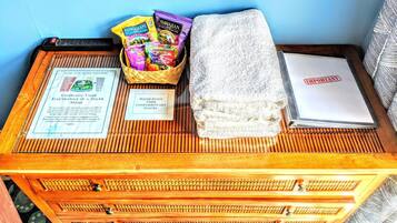 A wooden chest with a sign about solar charging, a basket of snacks, a towel, and a white folder with a red stamp.