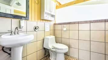 A bathroom with a white sink, toilet, and tiled walls.