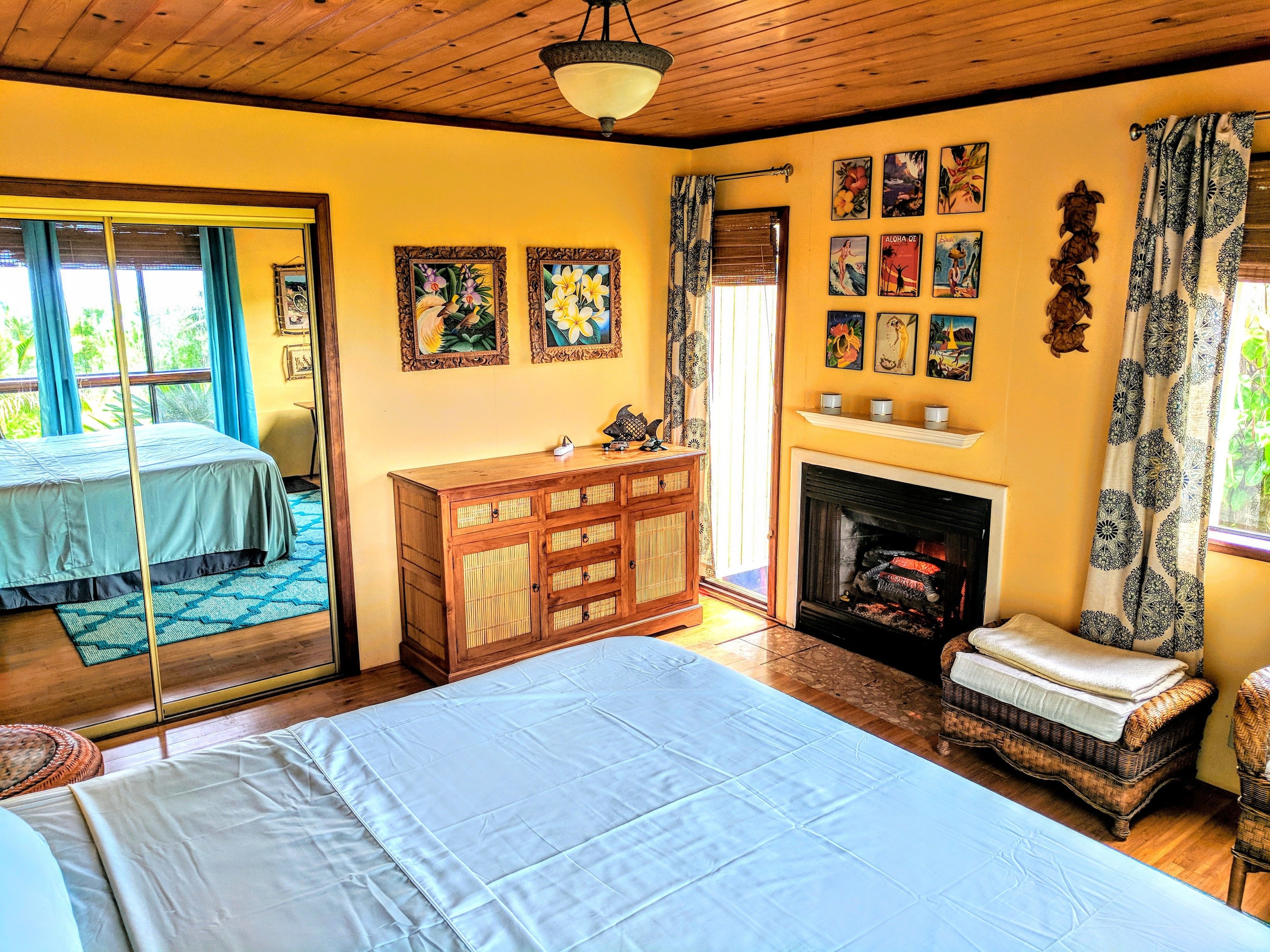 Una habitación con cama, cómoda, chimenea y ventana con cortinas.