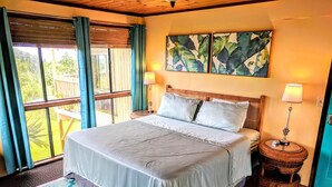 Une chambre spacieuse avec un grand lit, deux tables de chevet, une fenêtre avec des rideaux et une vue sur l’extérieur.