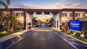 L’entrée d’un hôtel, avec un passage couvert, un parking et un panneau indiquant « Express Inn & Suites ».