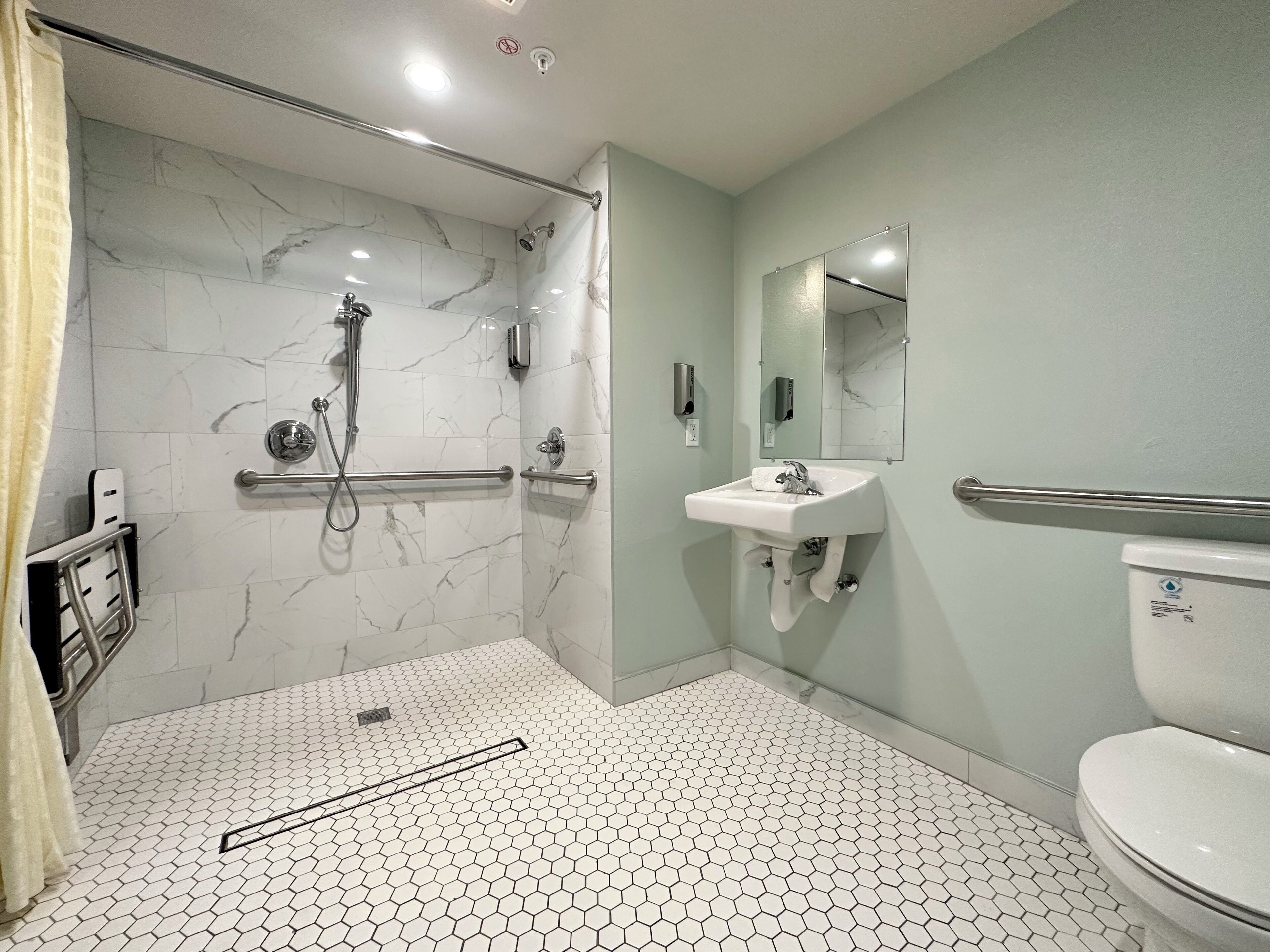 A modern bathroom with a shower, toilet, and sink.